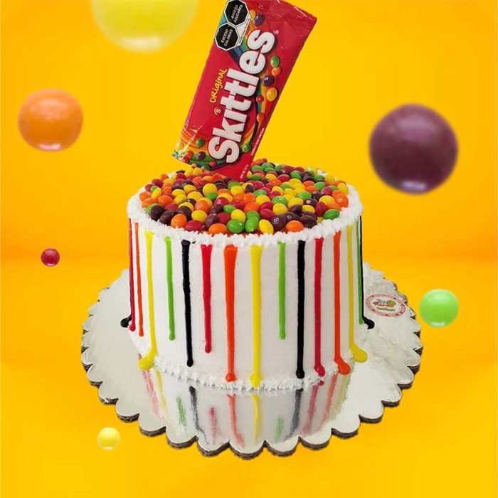 Pastel de Skittles. Pastel con cubierta de betún. Con decoración de Skittles y drip de colores.